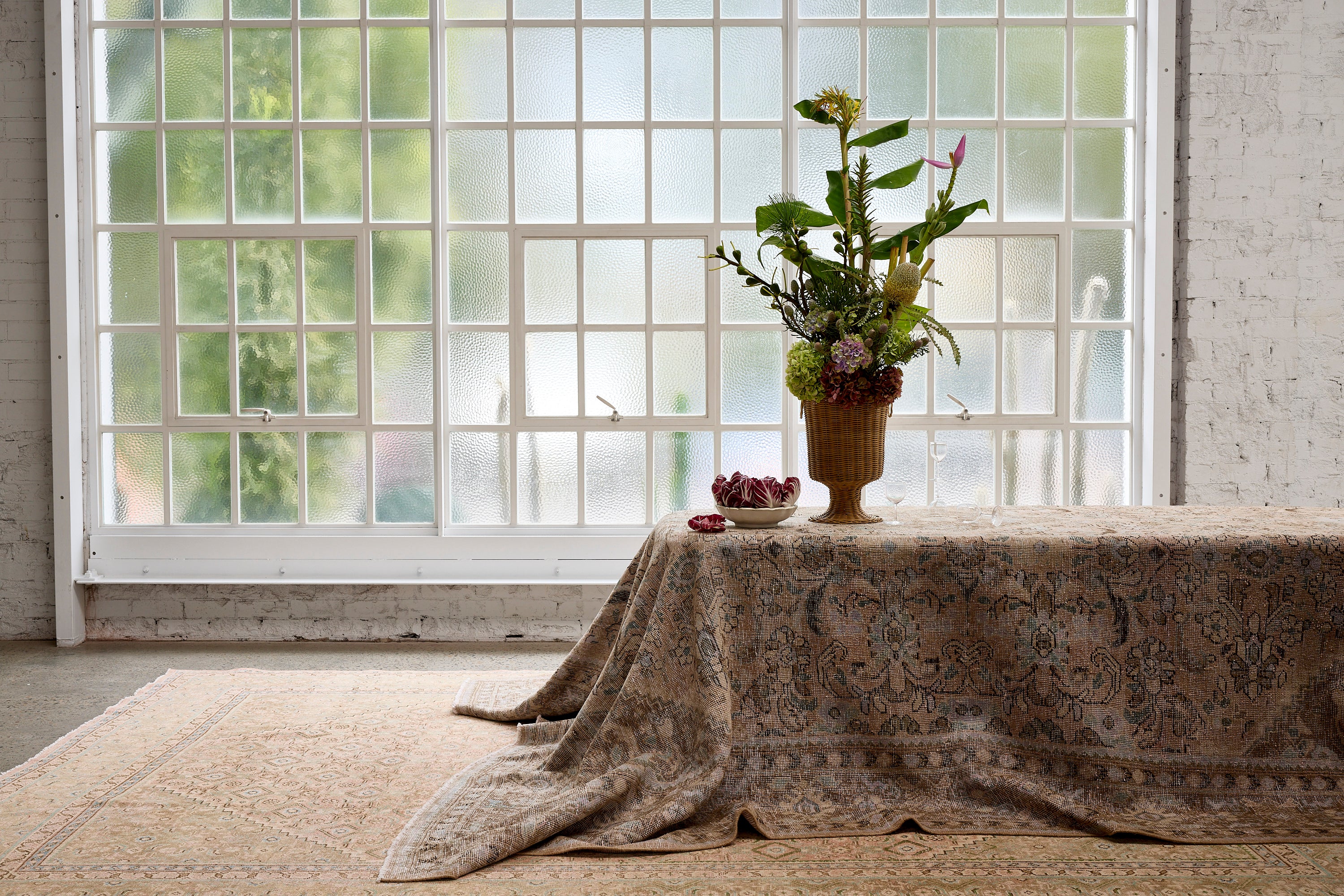 Persian vintage rugs displayed in a room for photoshoot with flowers and leaves