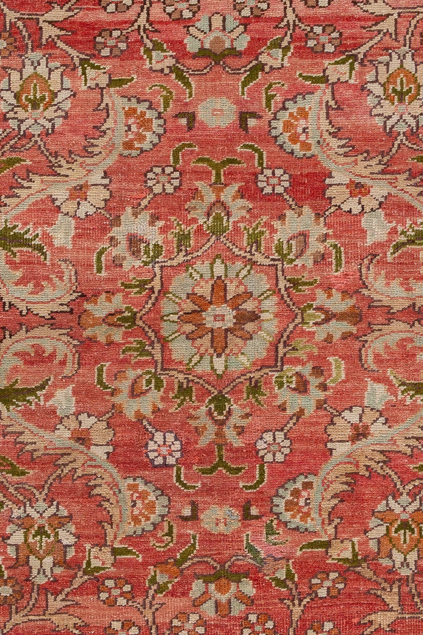 Close-up of a small rug with terracotta, red, green, and beige colors, called Vintage Persian Tabriz.